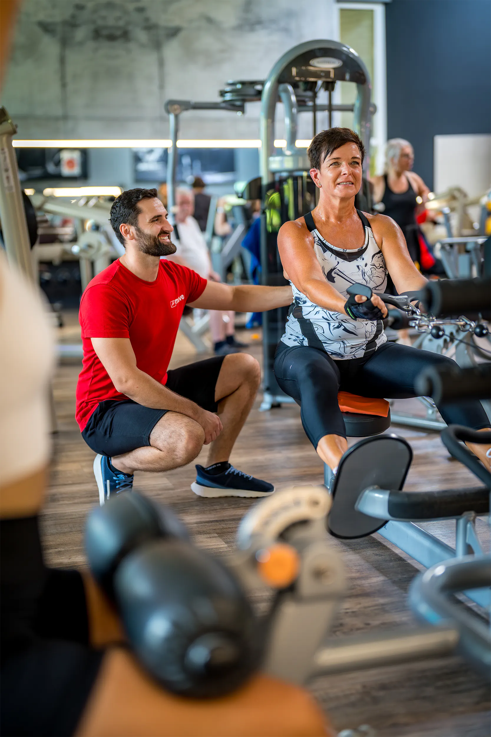 Trainer betreut Mitglied beim Training am Gerät im move Studio