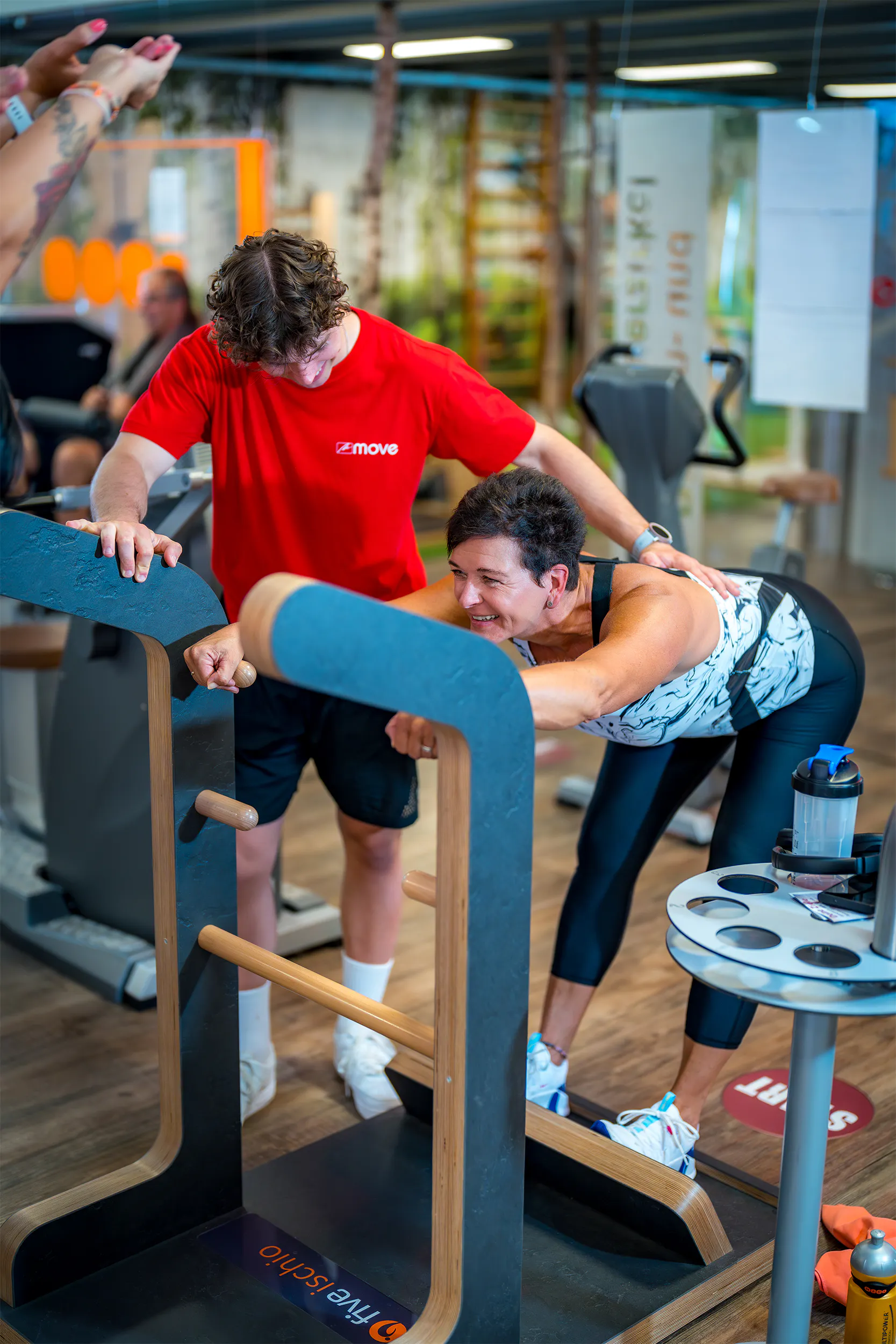 Trainer betreut Mitglied beim Kurzhanteltraining im move Studio