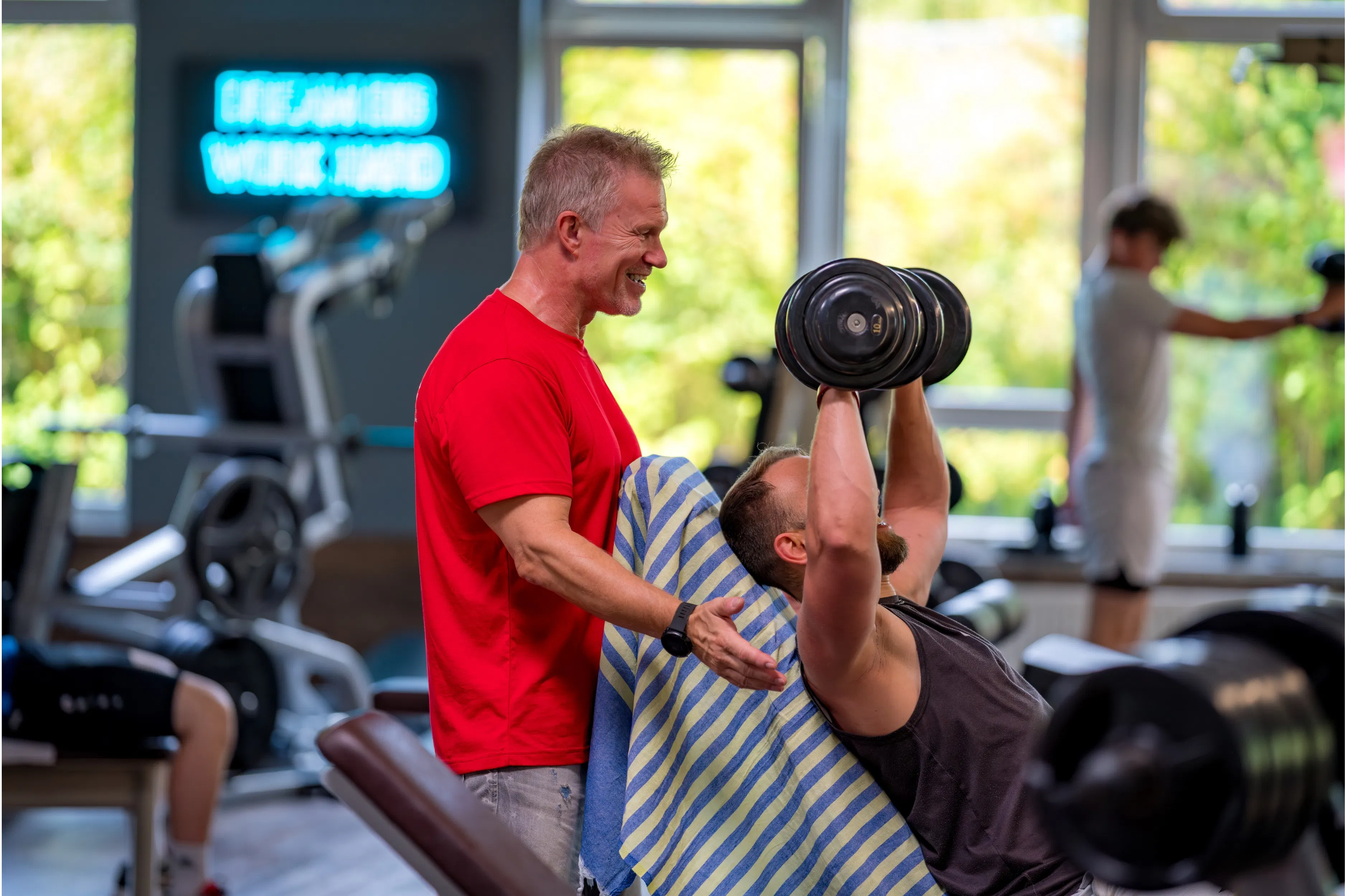 Trainer betreut Mitglied beim Kurzhanteltraining im move Studio
