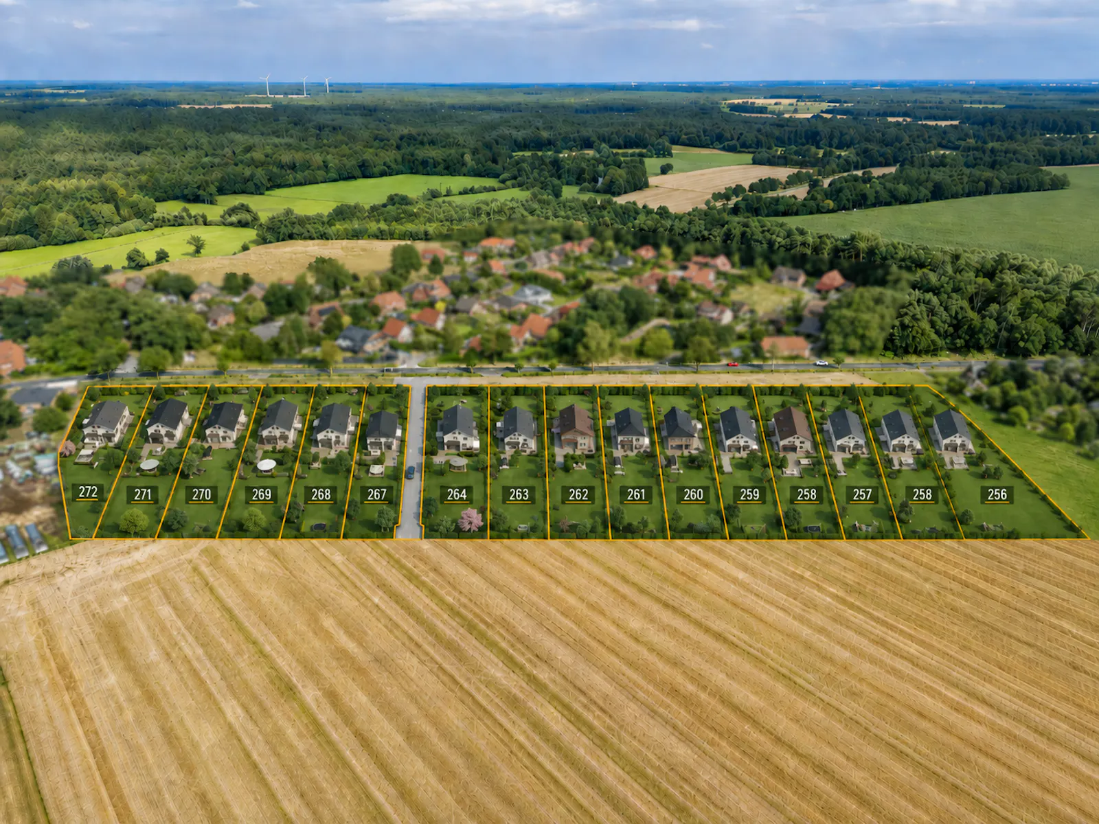Reihenhausgrundstücke mit Hausnummern von 256 bis 272, umgeben von Feldern und Wäldern in ländlicher Umgebung mit Windrädern am Horizont.