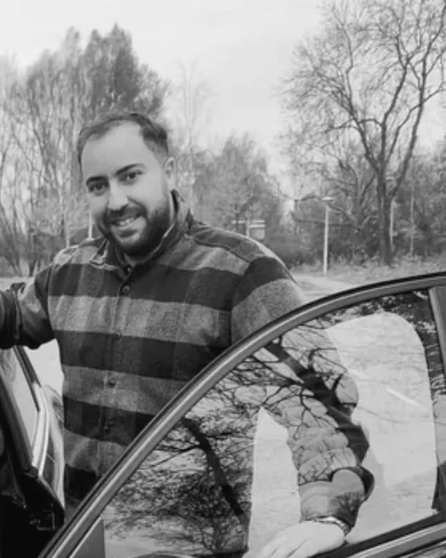 Rijinstructeur Hamid bij de lesauto van Verkeersschool Capabel