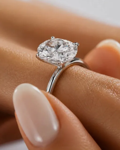 Close-up of a hand wearing a silver ring with a large cushion-cut clear gemstone.