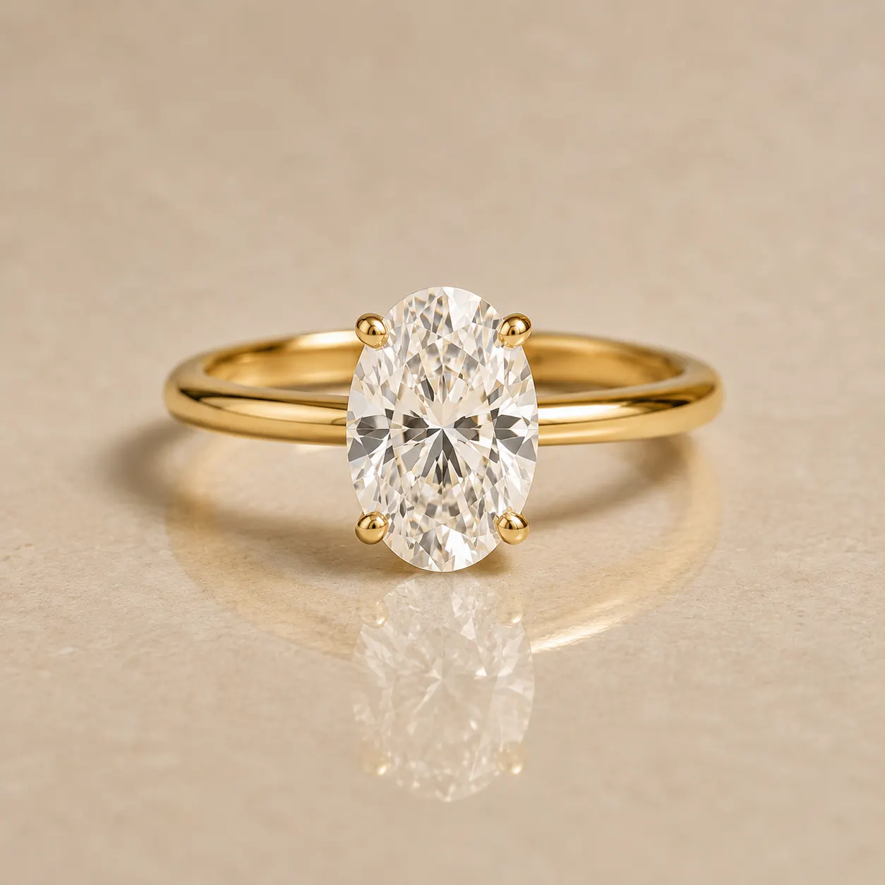 Gold ring with a large oval-cut clear diamond held by four prongs on a beige reflective surface.