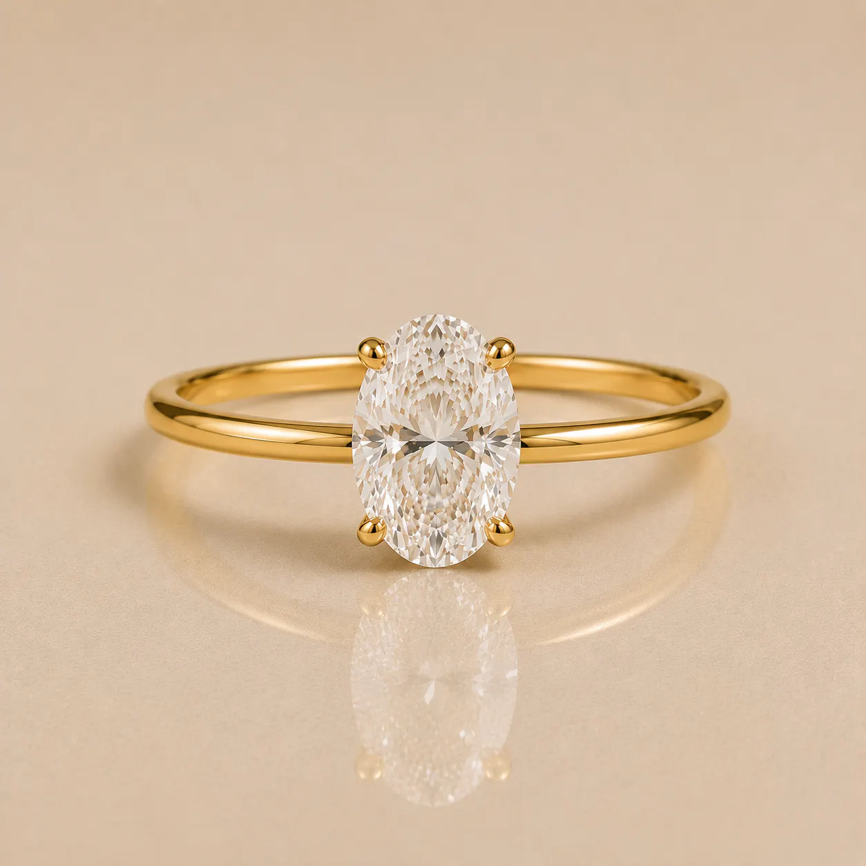 Gold ring with a large oval-cut clear diamond held by four prongs, placed on a smooth beige surface reflecting the ring.