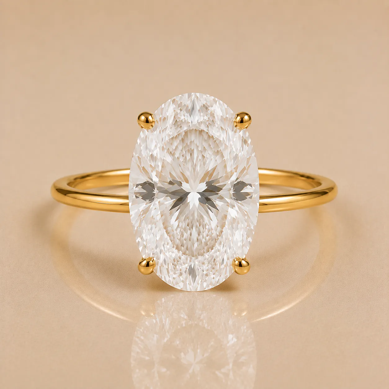 Gold ring with a large oval-shaped clear diamond held by four prongs on a beige background with its reflection visible below.