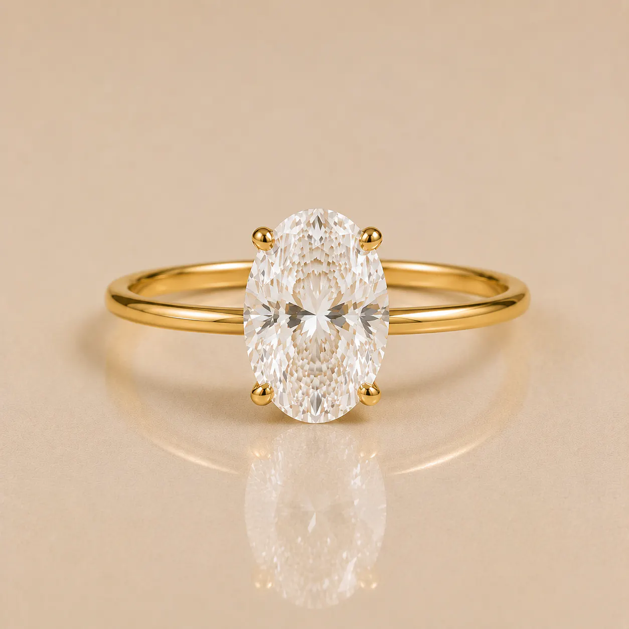 Oval-cut diamond solitaire set on a thin gold band with four prongs holding the diamond in place.
