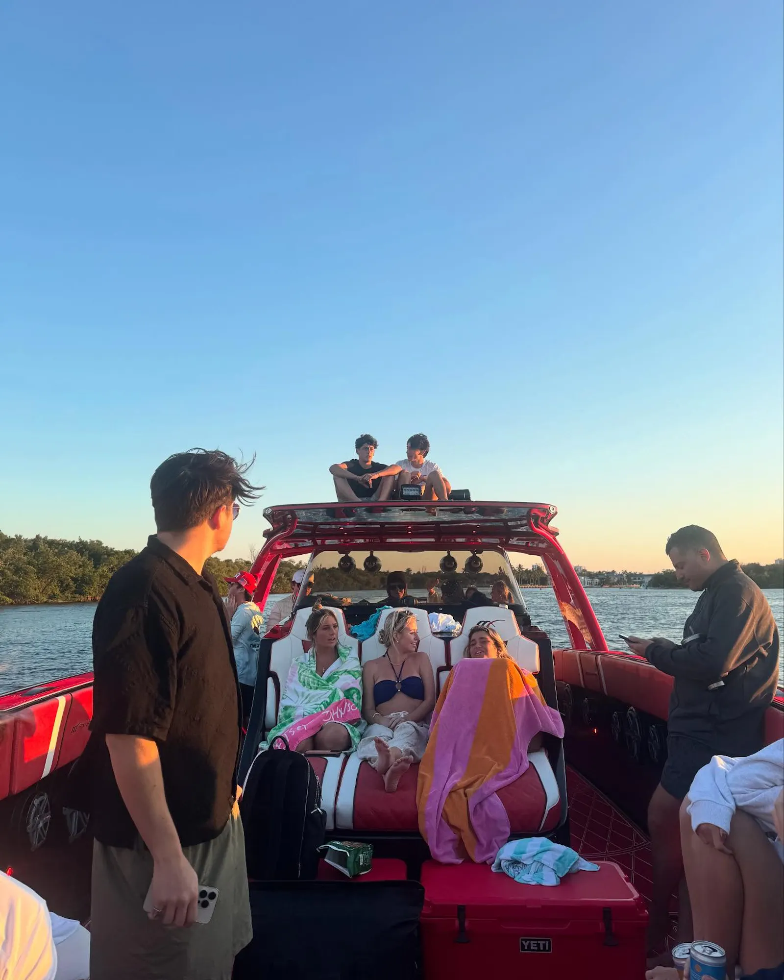 friends on speedboat at sunset