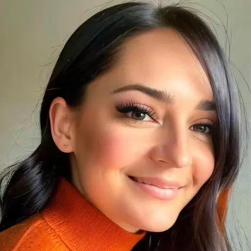 Woman with long dark hair wearing an orange turtleneck sweater smiling softly at the camera.