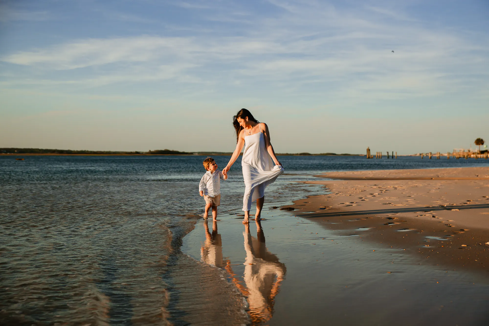 Mother and toddler walking along the shoreline