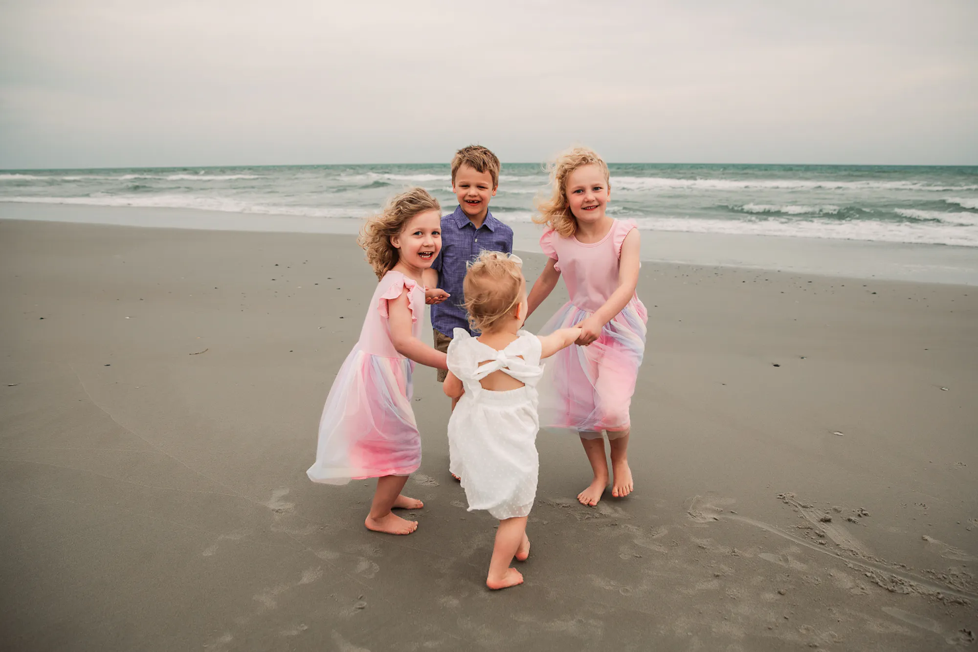 Four children playing together on the beach