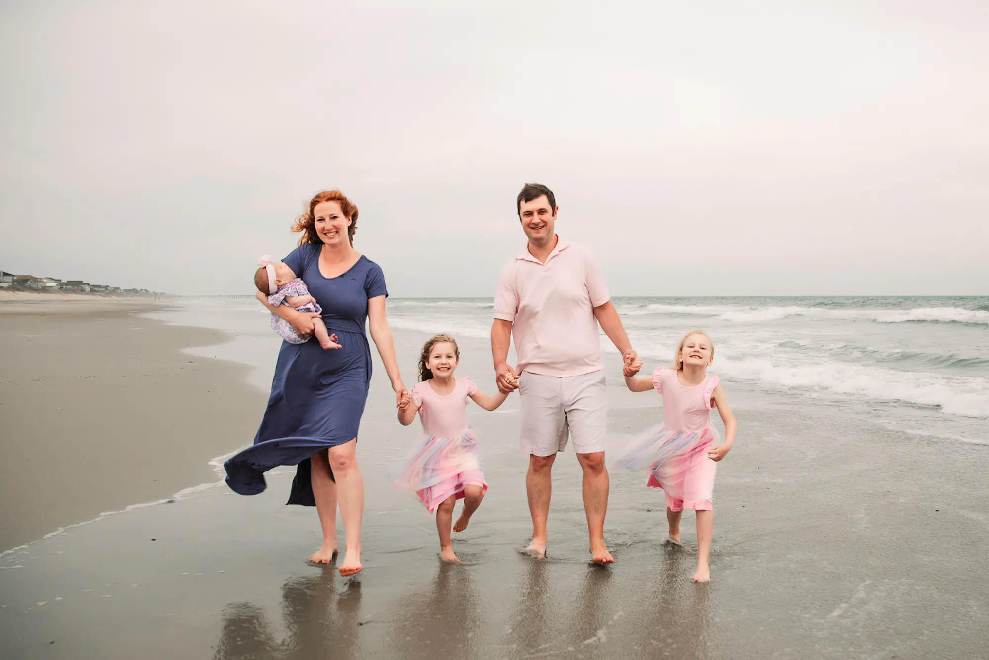 Family of five walking together on the beach