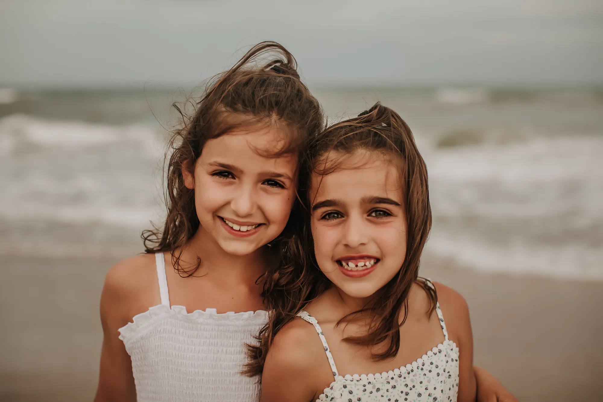 Two sisters smiling on the beach