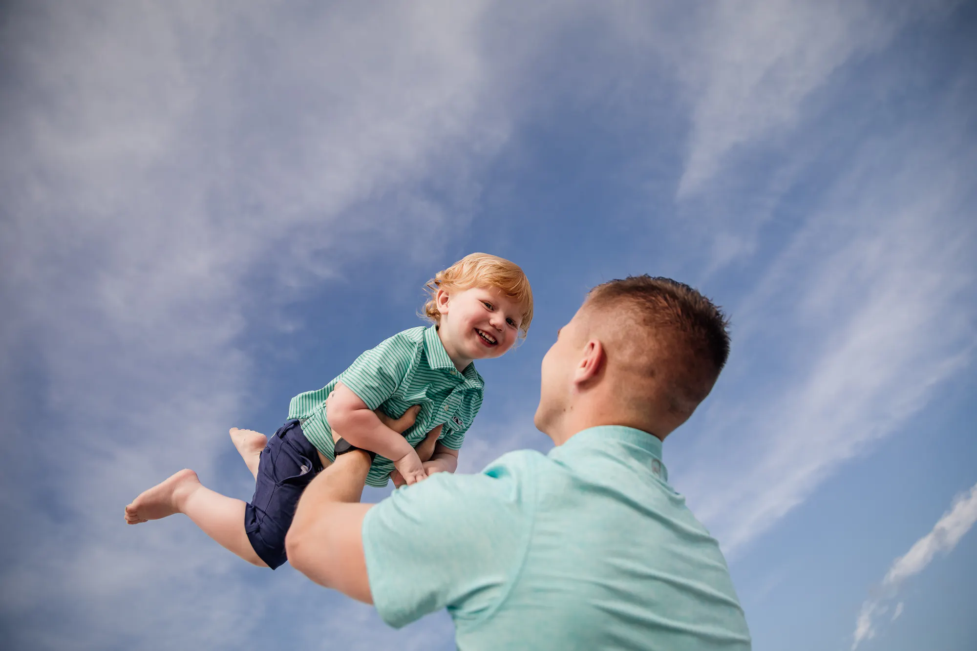 Father lifting his son toward the sky