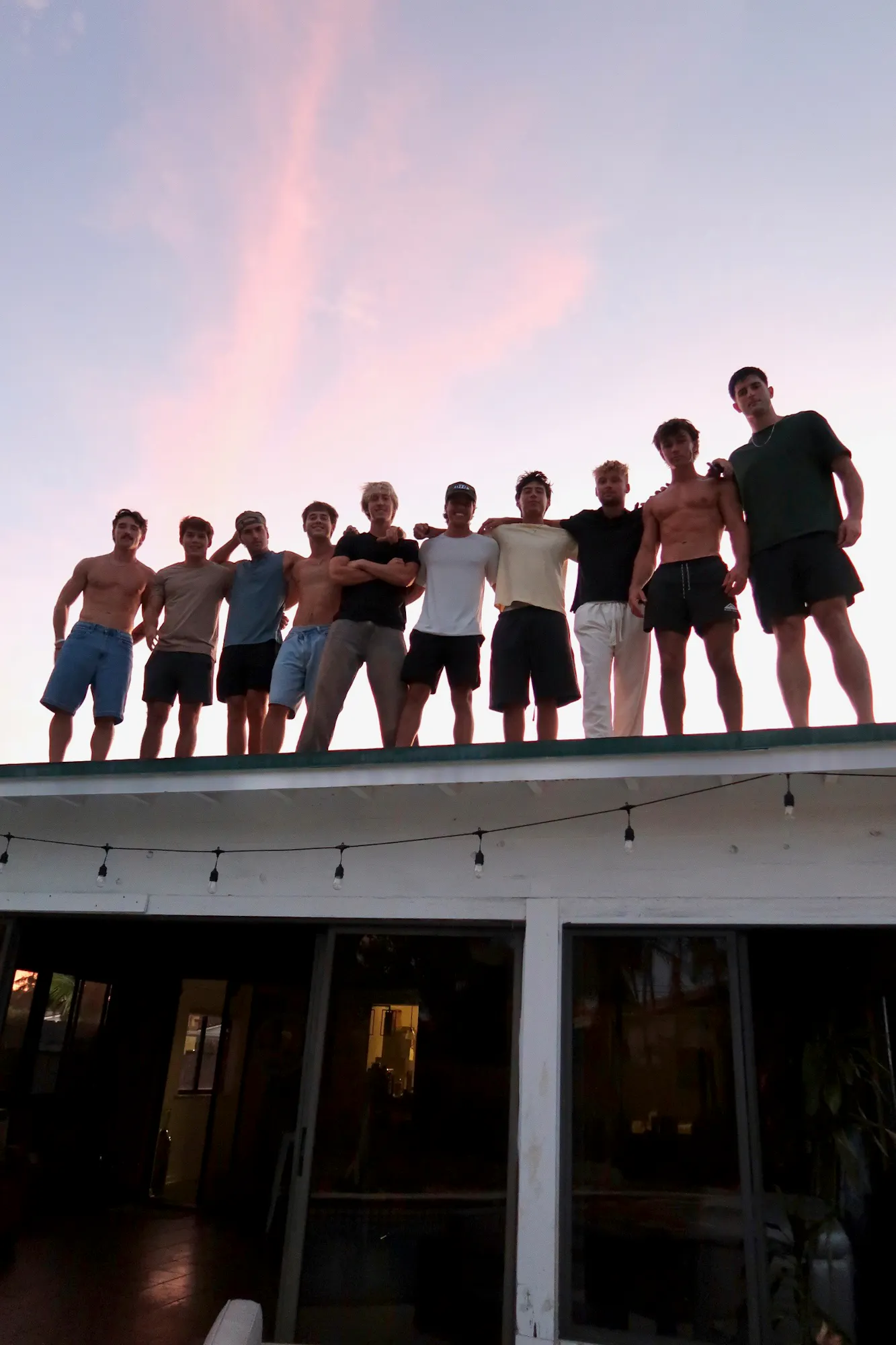 group of men on rooftop at sunset