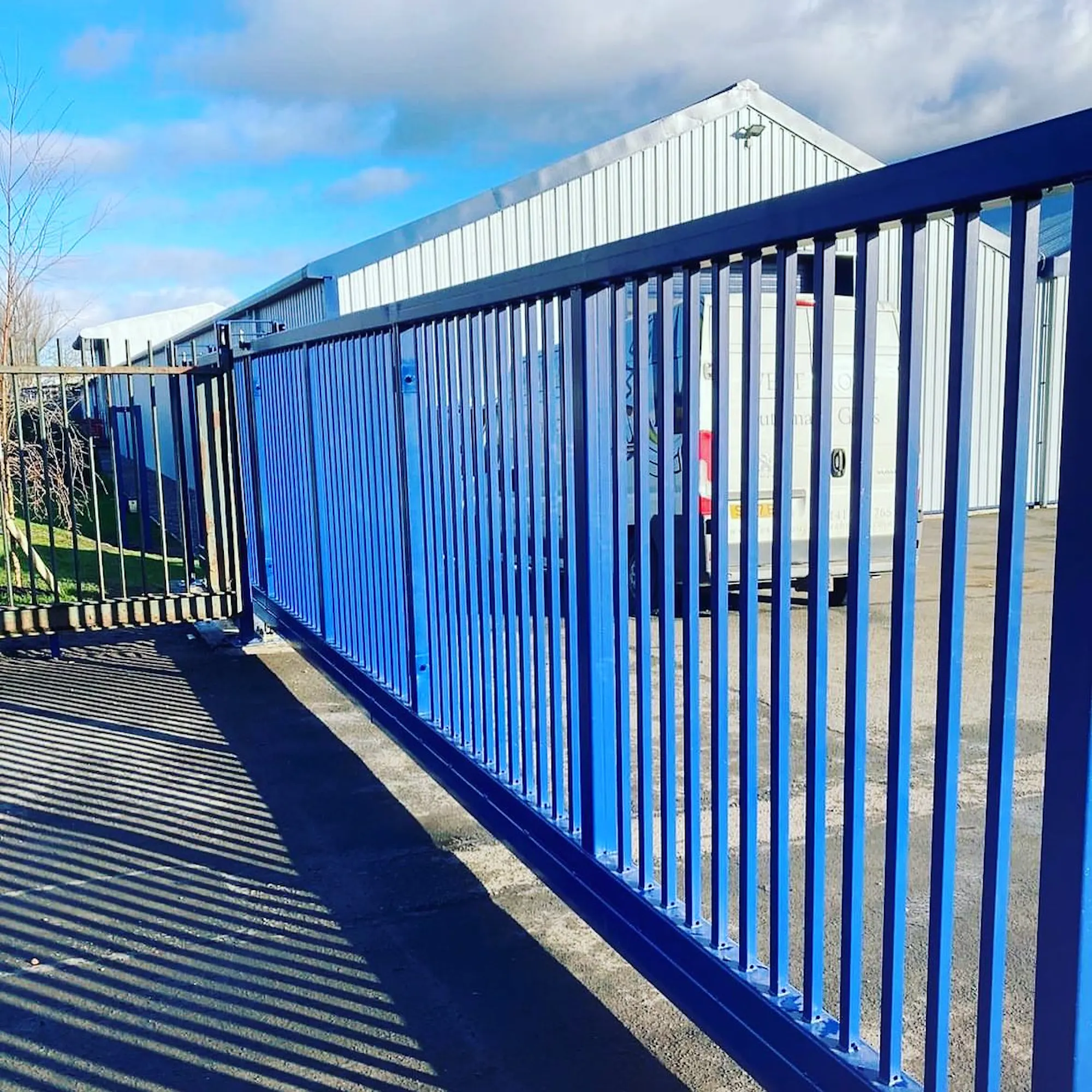 Blue sliding security gate at a commercial industrial unit