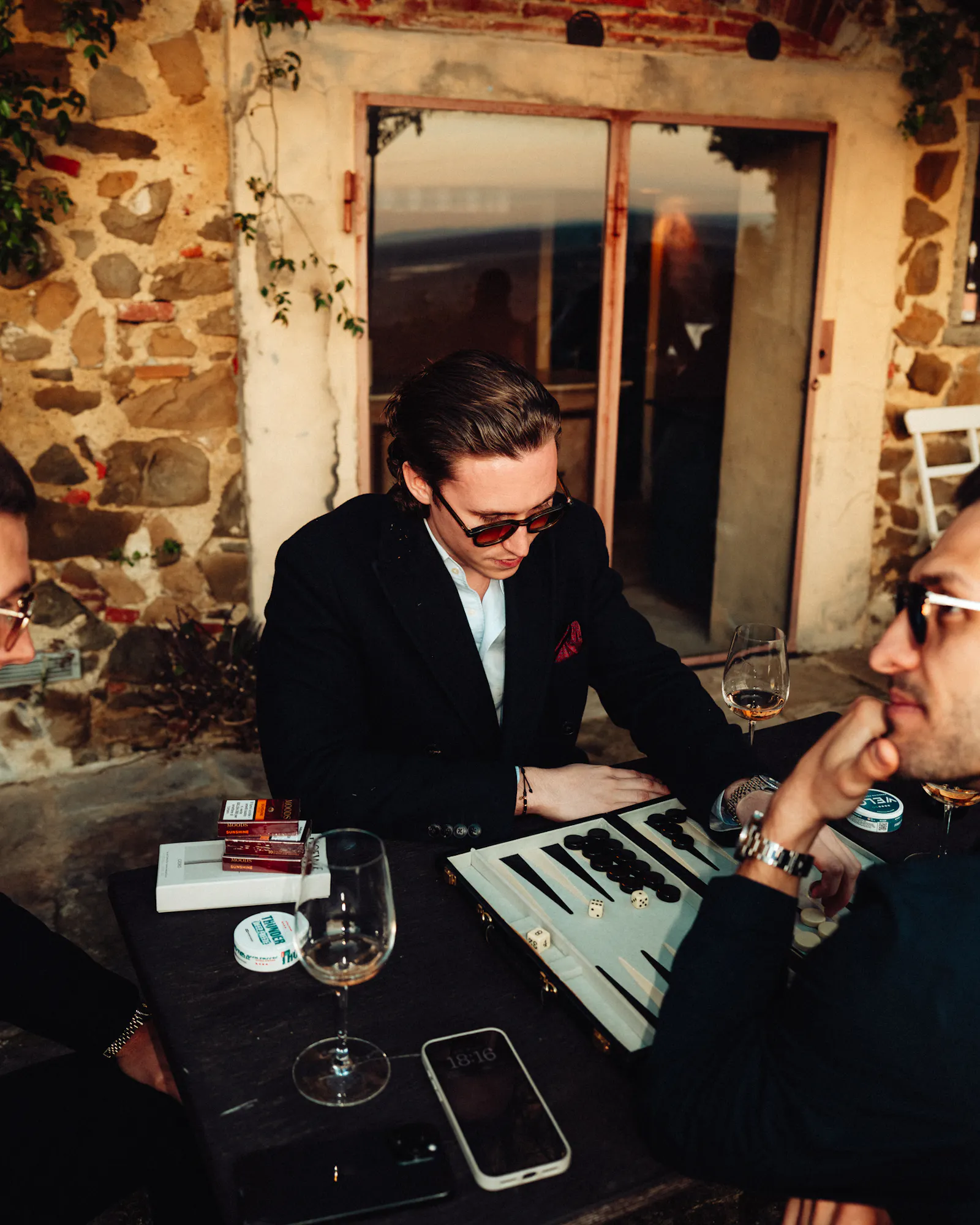 Gäste beim Backgammon mit Wein am Abend