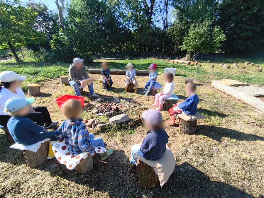 Sitzkreis mit Kindern und Begleitung auf der Ranch