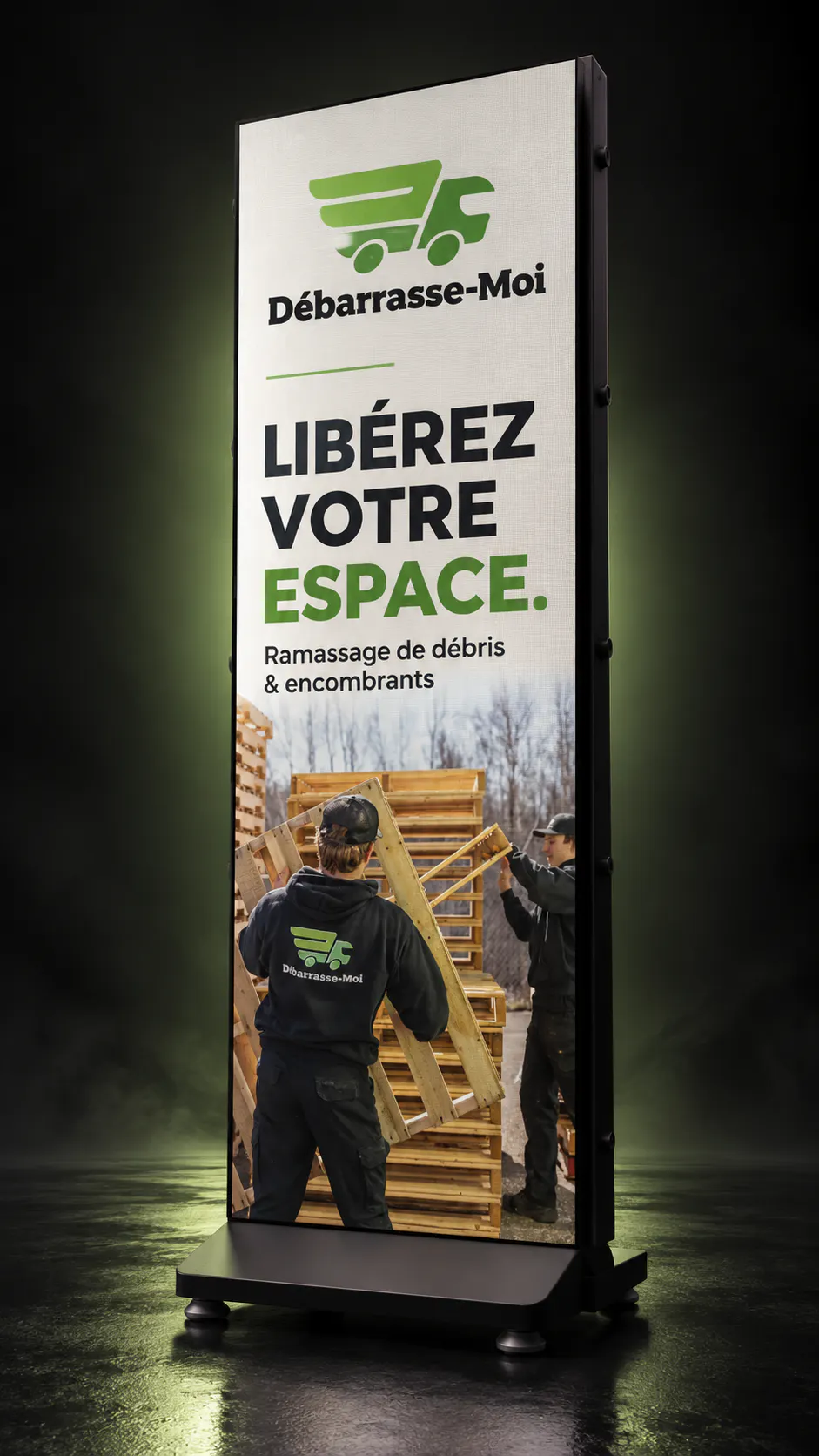Workers in black uniforms with a green logo are handling wooden pallets outdoors, with text promoting debris and bulky item removal in French.