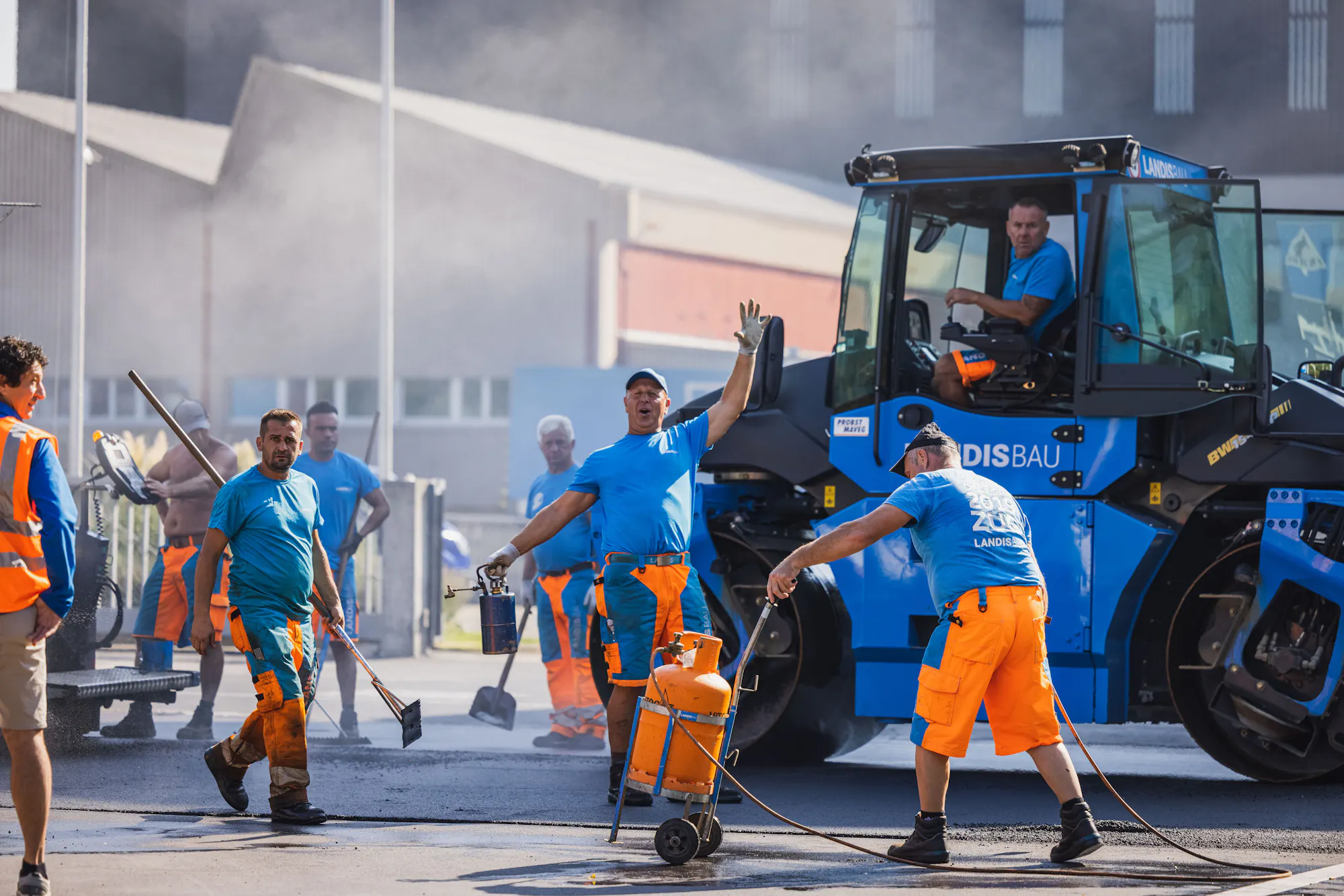 Landis-Bau-Team beim Belagseinbau mit Walze