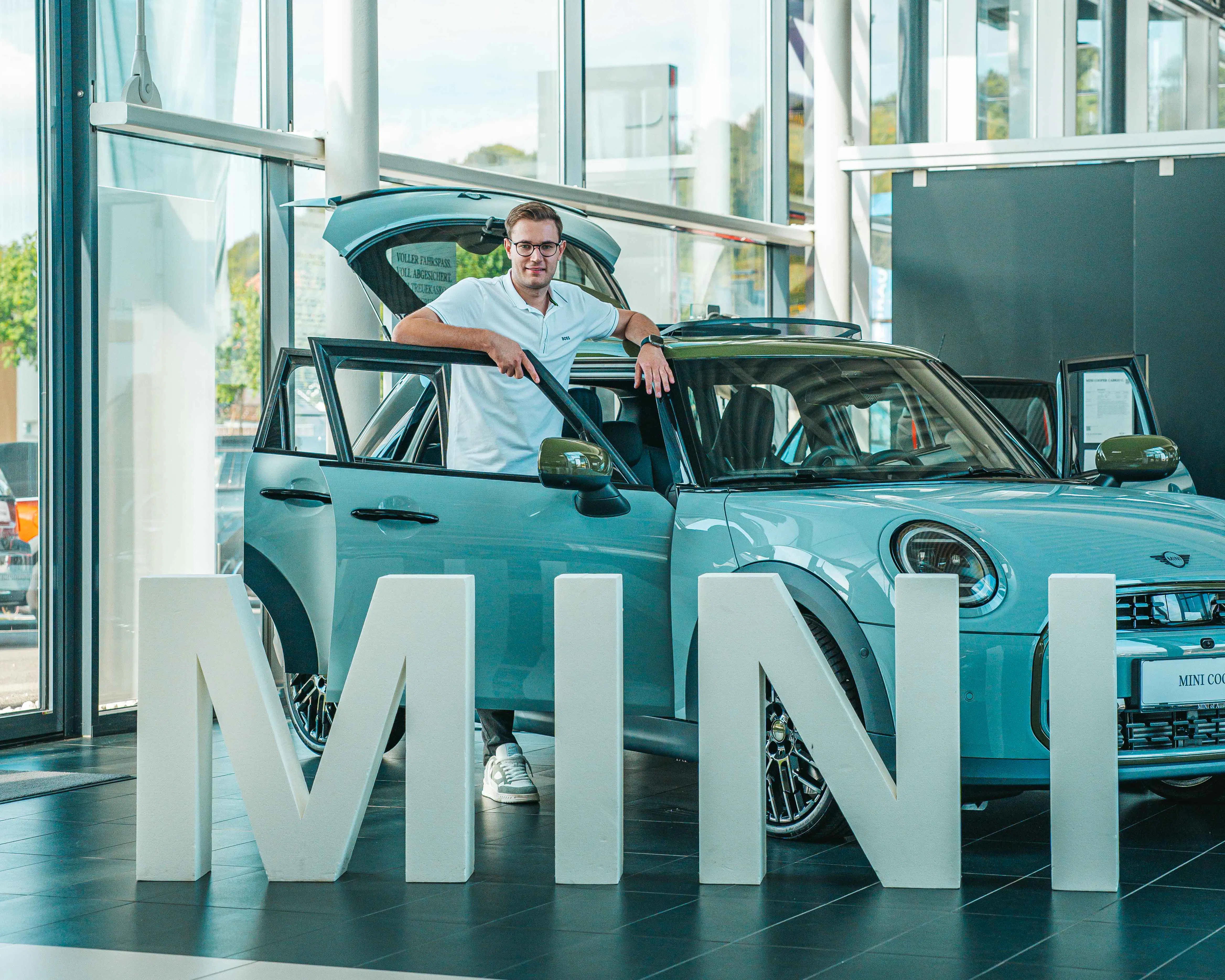 Moritz König, MINI Verkaufsberater bei driveME Regau, an einem MINI im Schauraum