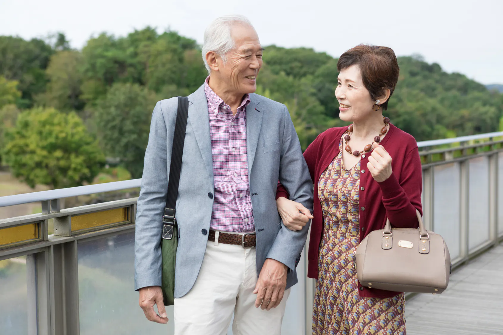 Retired couple walking arm in arm outdoors