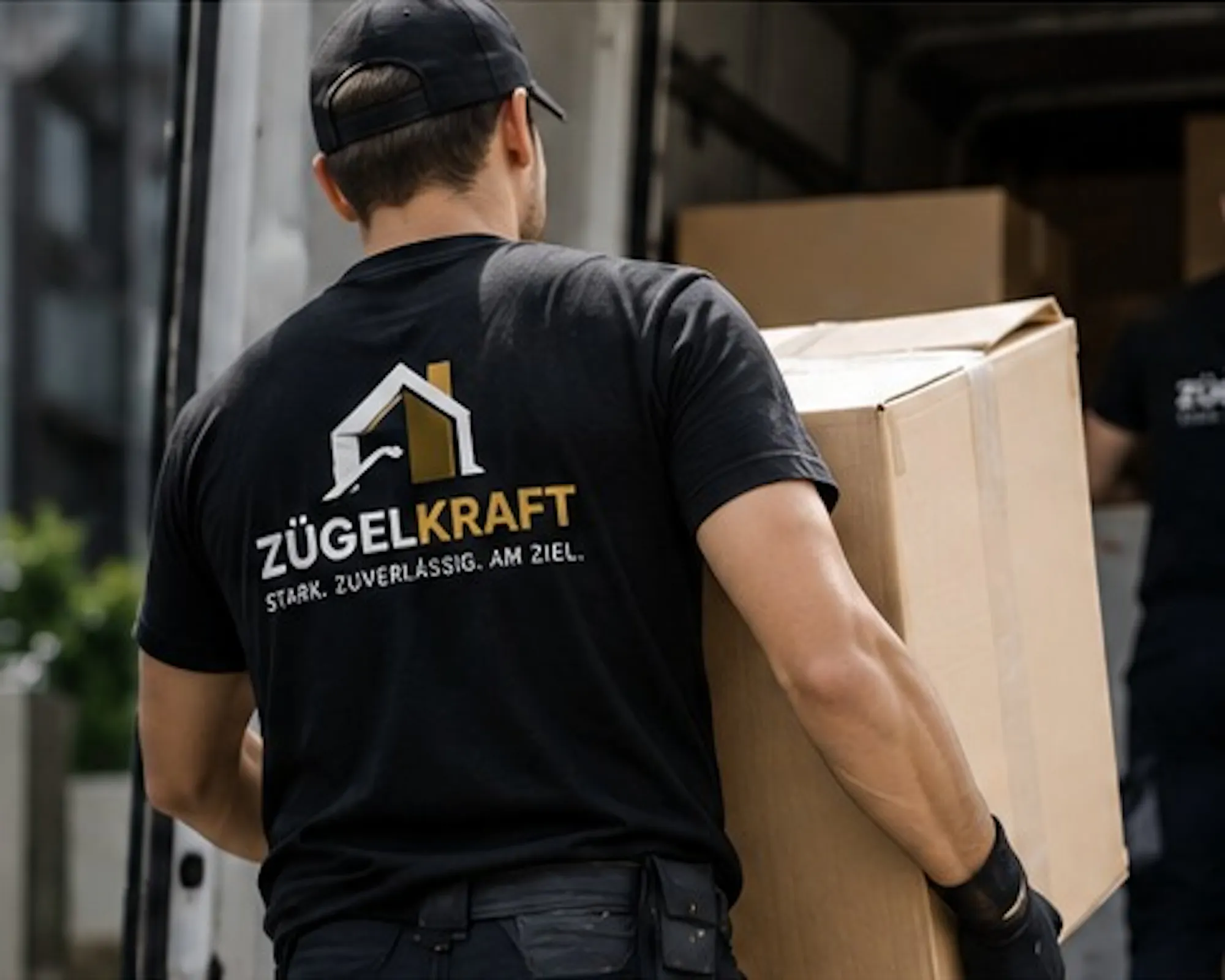 Zügelkraft-Mitarbeiter trägt einen Umzugskarton zum Umzugswagen