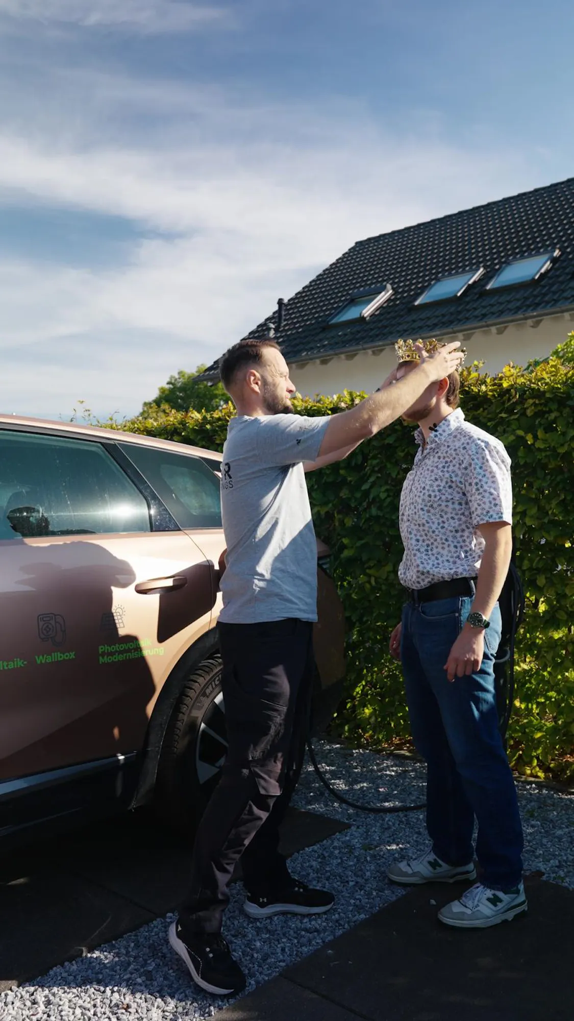 Pieter von SolarKings setzt einem Kunden vor seinem Haus eine Krone auf