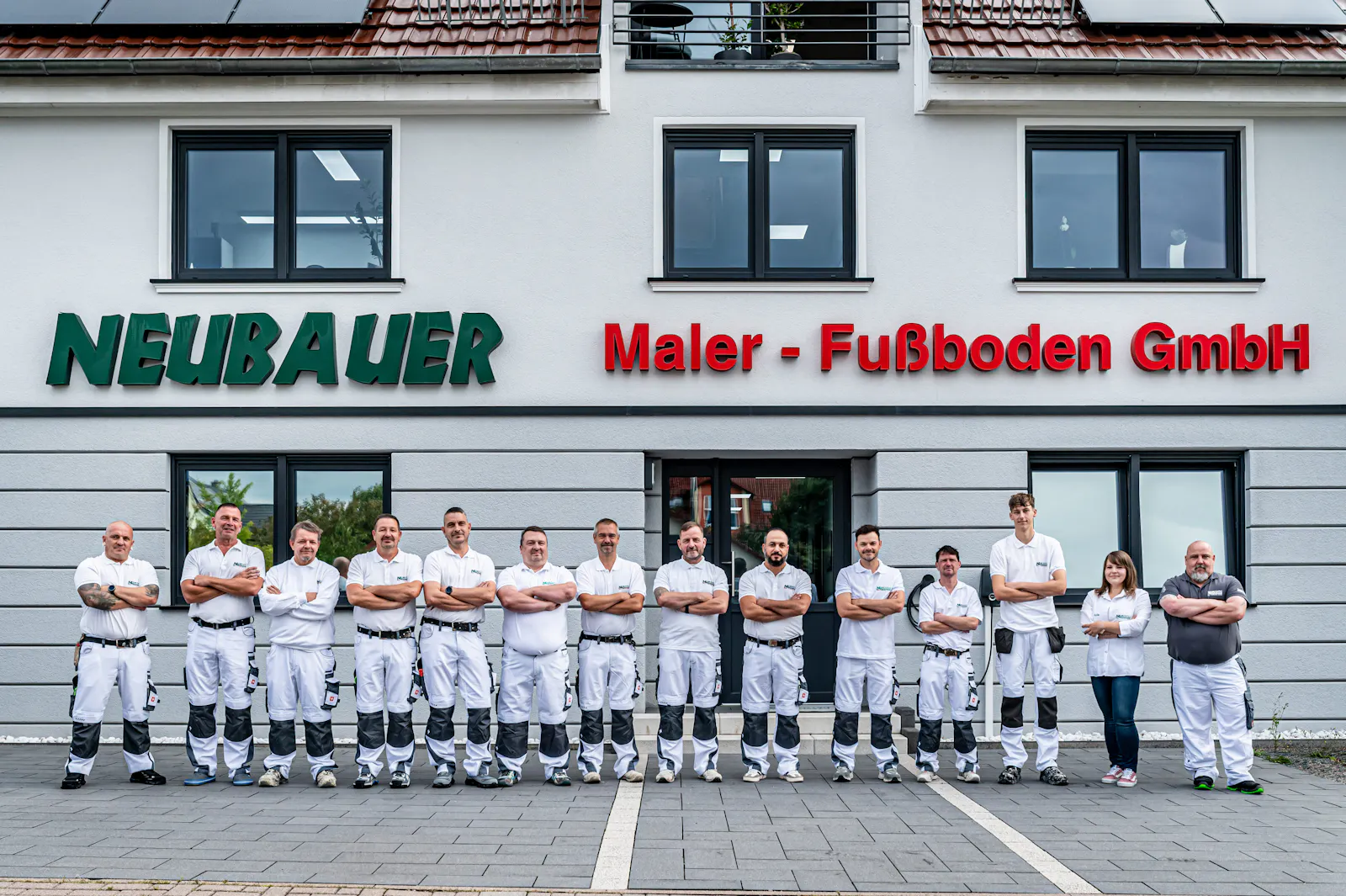 Team in Arbeitskleidung vor dem Firmengebäude