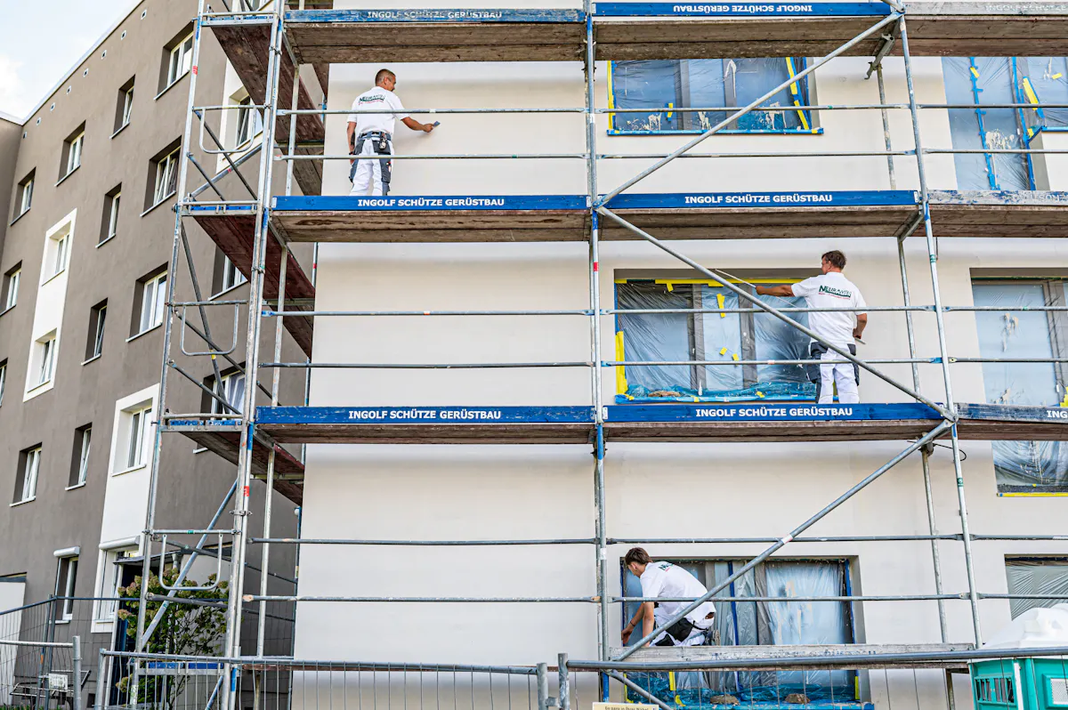 Maler an der Fassade auf dem Gerüst