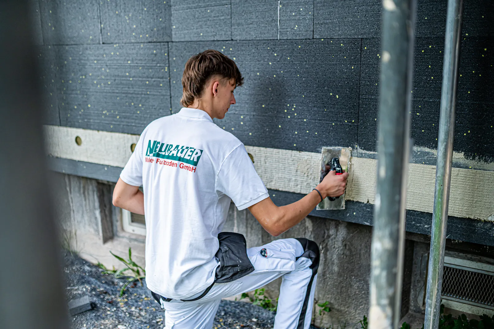 Auszubildender beim Arbeiten an der Fassadendämmung